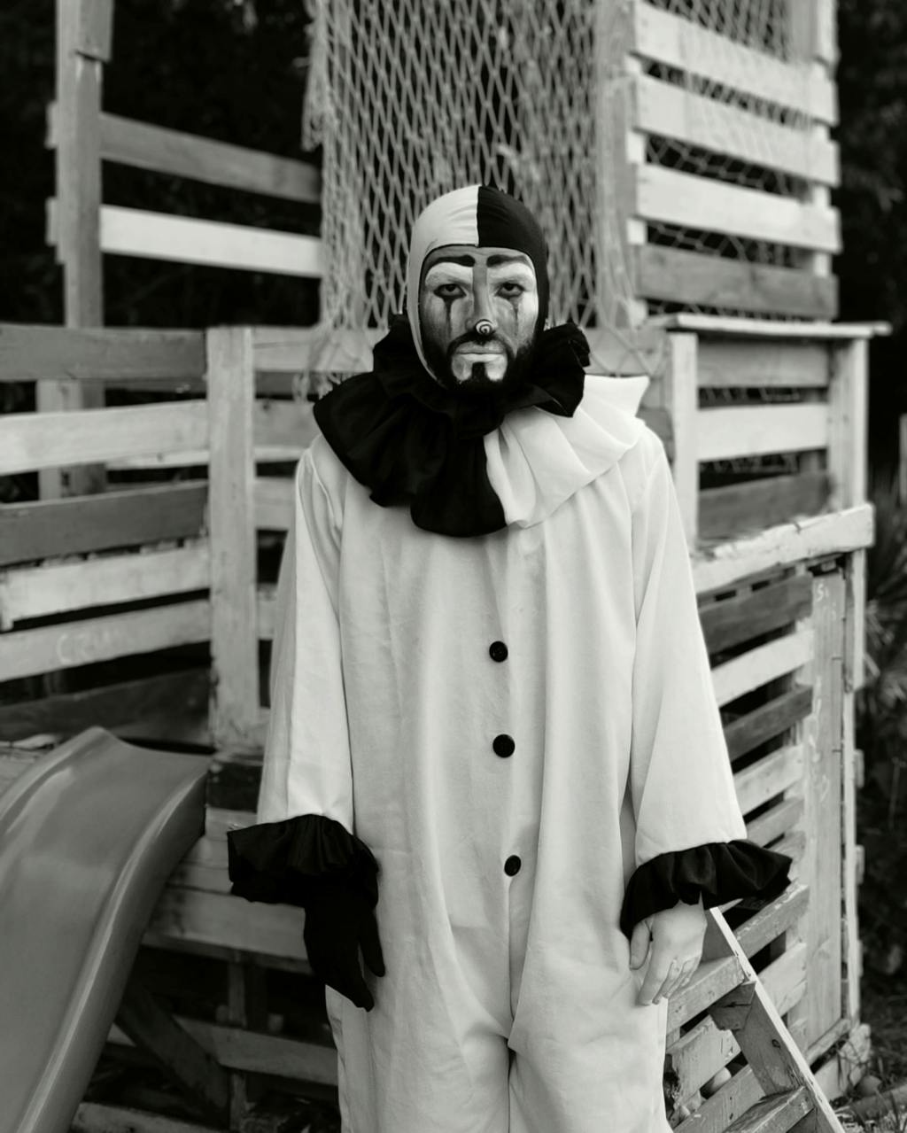 A man dressed in a black and white Pierrot costume